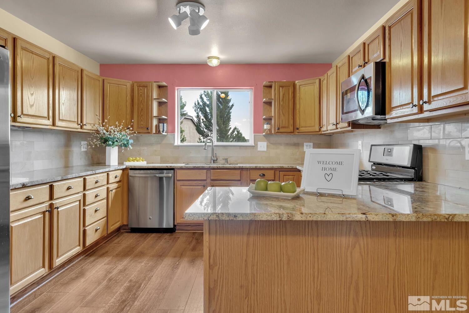 1031 University Ridge Drive Reno, NV 89512 - Photo 6 of 38 a kitchen with stainless steel appliances granite countertop a sink stove and cabinets