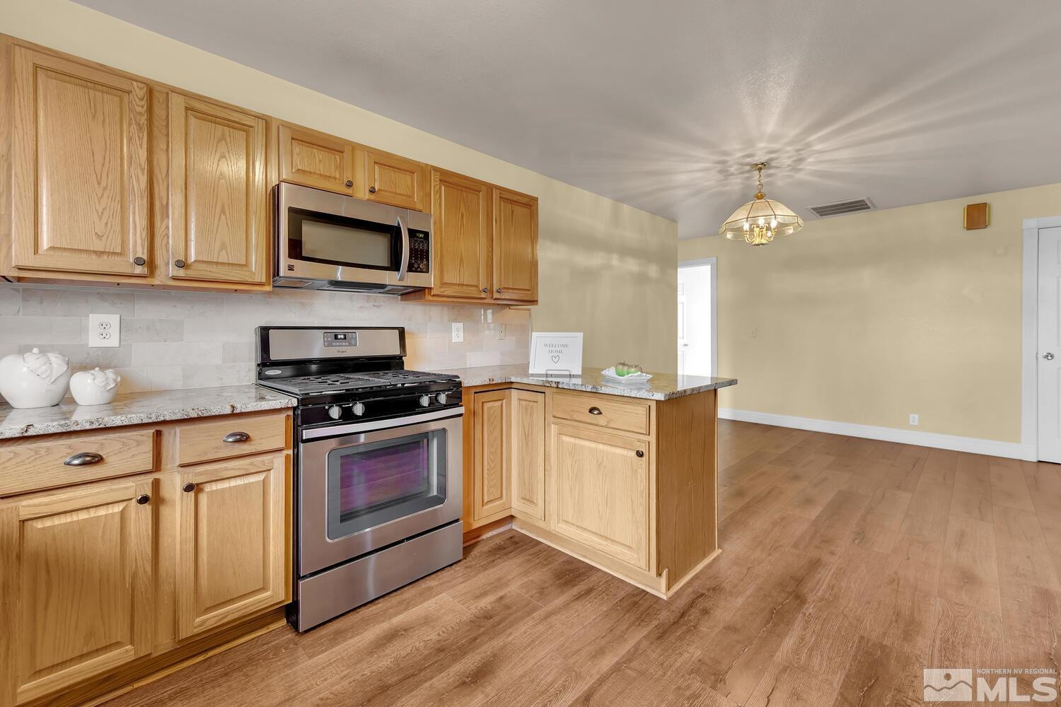 1031 University Ridge Drive Reno, NV 89512 - Photo 9 of 38 a kitchen with stainless steel appliances granite countertop a stove a sink and a microwave