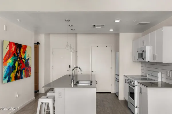 a kitchen with stainless steel appliances a stove a sink and a refrigerator