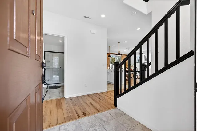 a view of a hallway with wooden floor and stairs