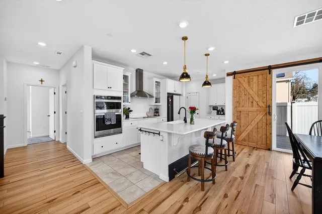 a open kitchen with stainless steel appliances kitchen island granite countertop a refrigerator and cabinets
