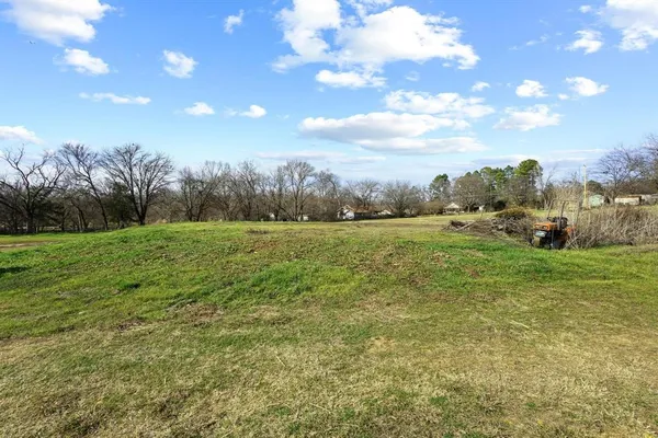 a view of a field with an trees in the background