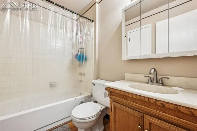 a bathroom with a granite countertop sink a toilet and bathtub
