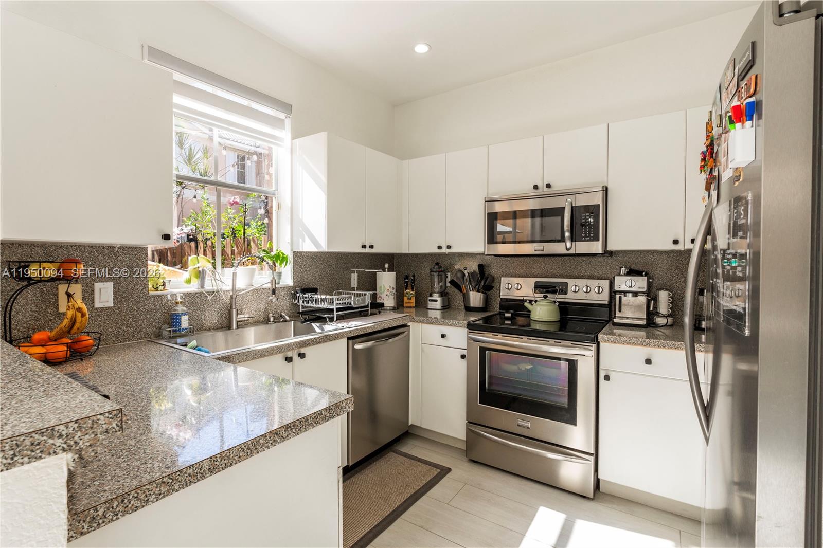 12478 Southwest 123rd Street Miami, FL 33186 - Photo 12 of 34 a kitchen with stainless steel appliances granite countertop a stove sink and microwave