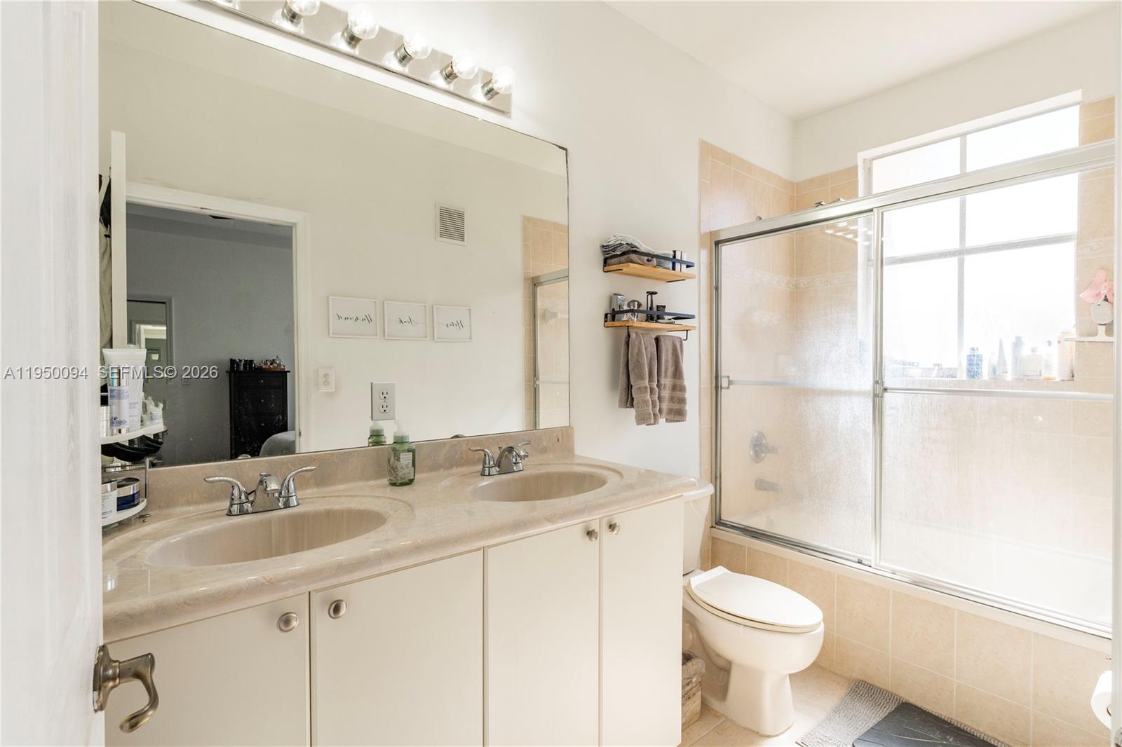 12478 Southwest 123rd Street Miami, FL 33186 - Photo 24 of 34 a bathroom with a sink toilet a mirror and shower