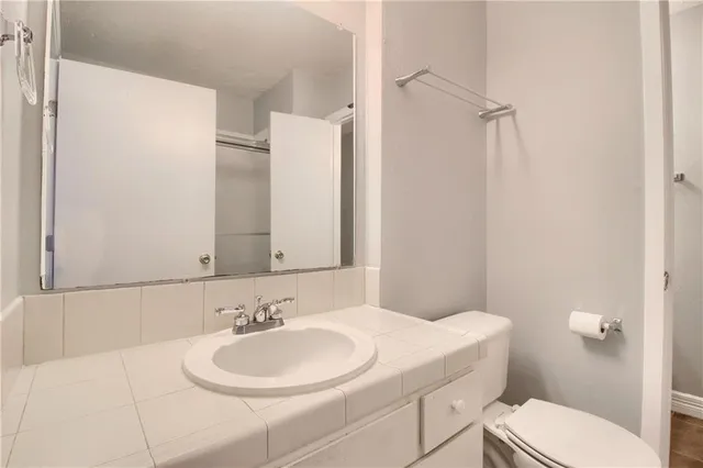 a bathroom with a sink a toilet and a mirror