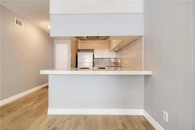 a view of a kitchen with wooden floor and a window