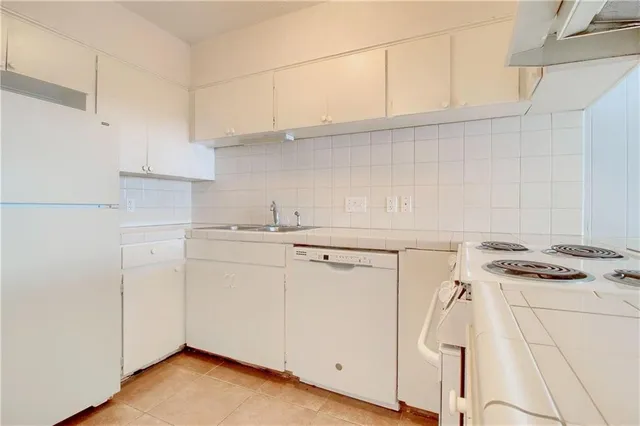 a kitchen with white cabinets and white appliances