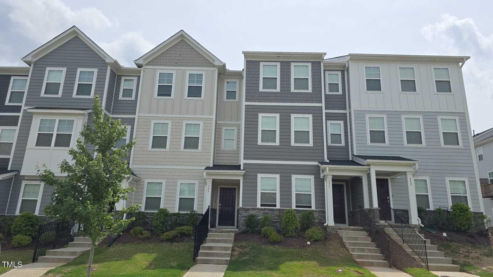 a front view of a house with yard and green space