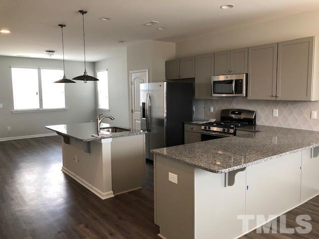 Undisclosed Address Wake Forest, NC 27587 - Photo 5 of 15 a kitchen with kitchen island a counter top space a sink cabinets and stainless steel appliances