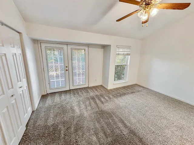 an empty room with closet and windows