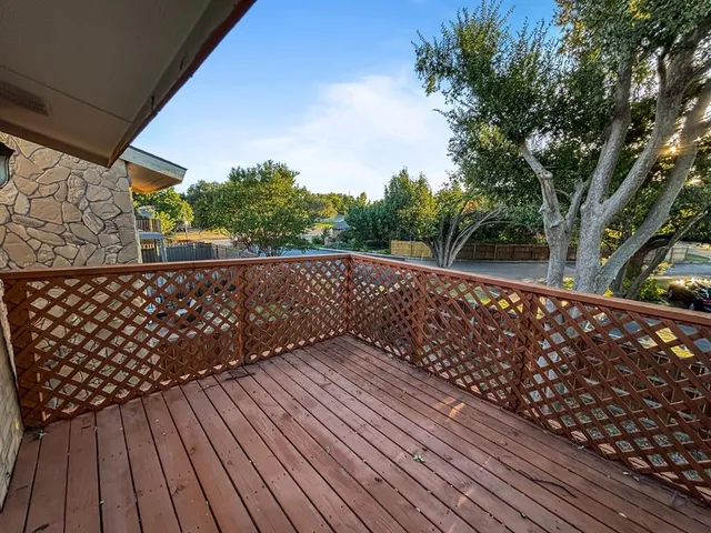 a balcony with wooden floor and fence