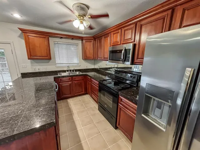 a kitchen with stainless steel appliances granite countertop a stove top oven a sink and dishwasher