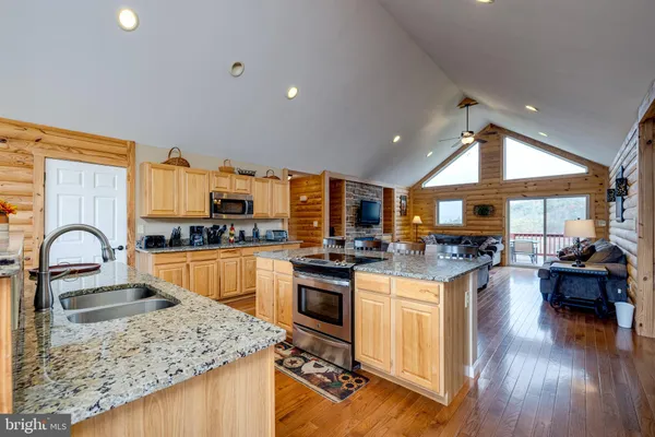a dining room with stainless steel appliances a table and chairs