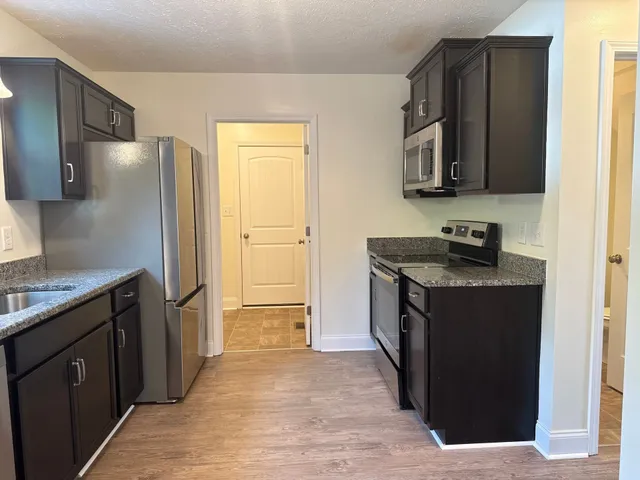 a kitchen with stainless steel appliances granite countertop a refrigerator and a sink