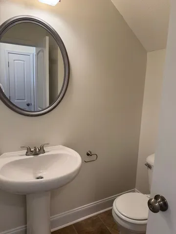 a bathroom with a sink a toilet and mirror