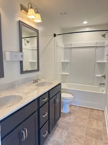 a bathroom with a granite countertop sink toilet a large mirror and shower