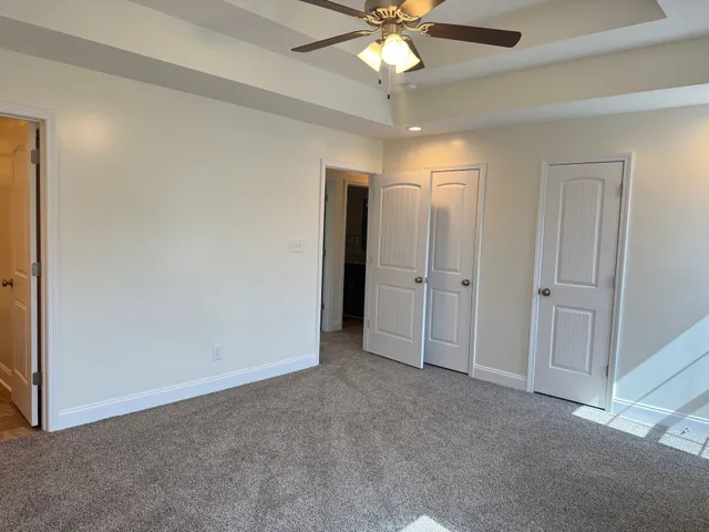 an empty room with fan and entryway