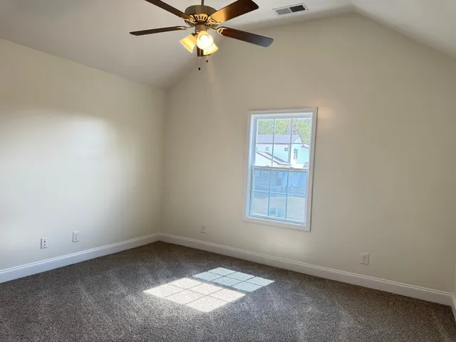 an empty room with a window and a fan