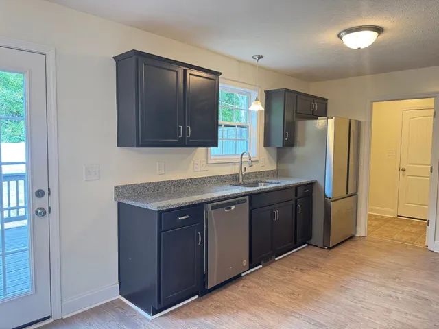 a kitchen with a refrigerator sink and cabinets