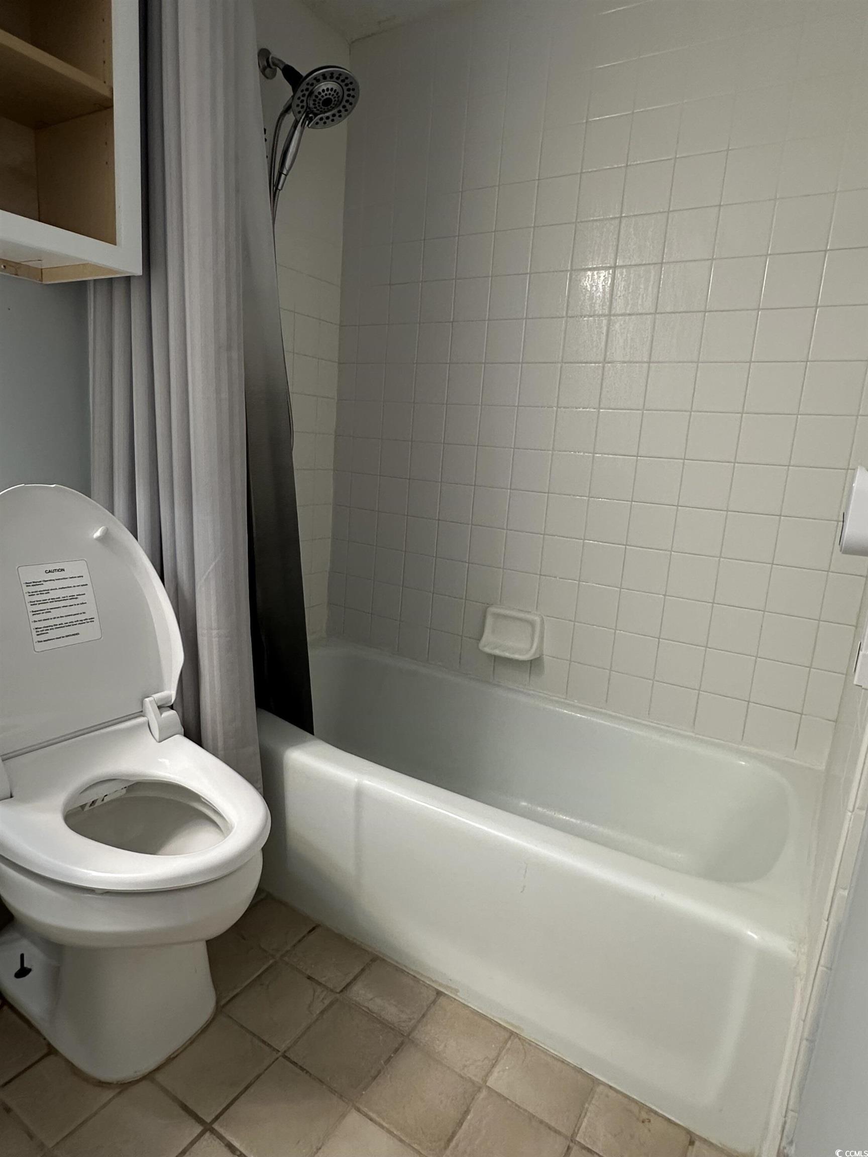 601 Mitchell Drive, Unit 1401 Myrtle Beach, SC 29577 - Photo 11 of 25 Full bathroom featuring shower / bath combination with curtain and tile patterned floors