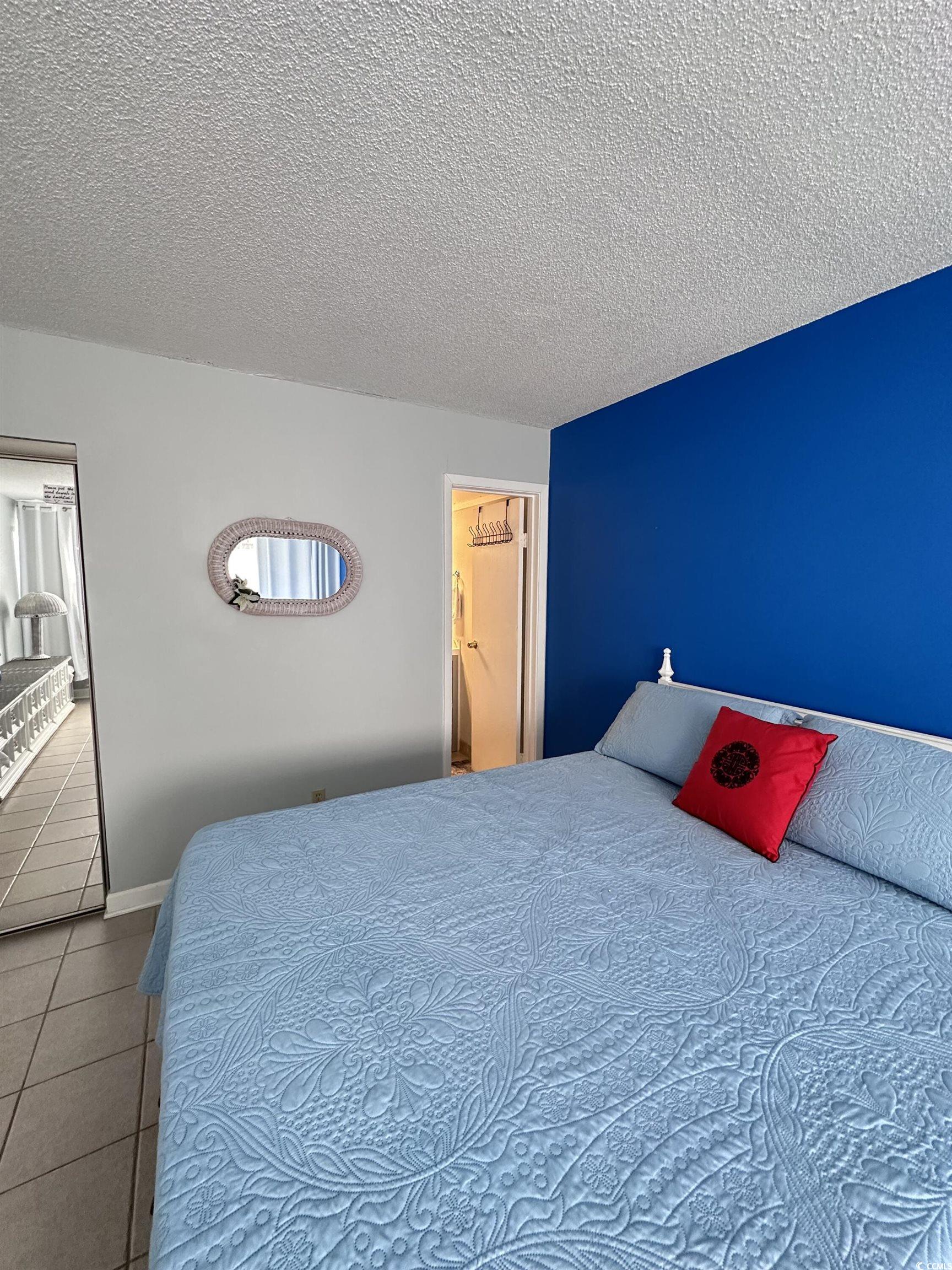 601 Mitchell Drive, Unit 1401 Myrtle Beach, SC 29577 - Photo 15 of 25 Bedroom with a textured ceiling and tile patterned flooring