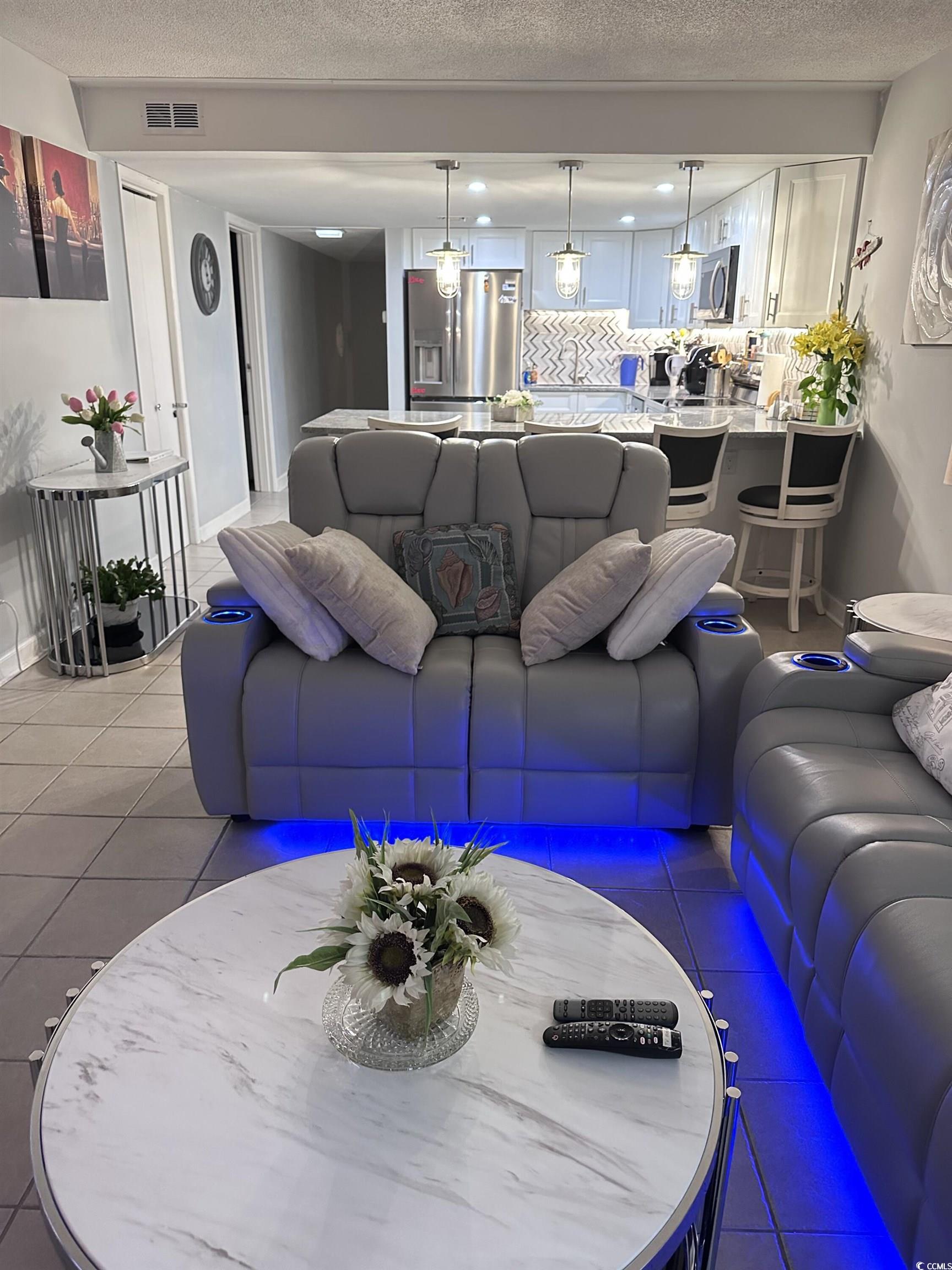 601 Mitchell Drive, Unit 1401 Myrtle Beach, SC 29577 - Photo 4 of 25 Living room with light tile patterned floors and a textured ceiling