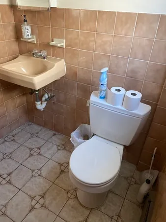 a bathroom with a sink toilet and a mirror