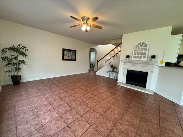 a view of empty room with fireplace and fan