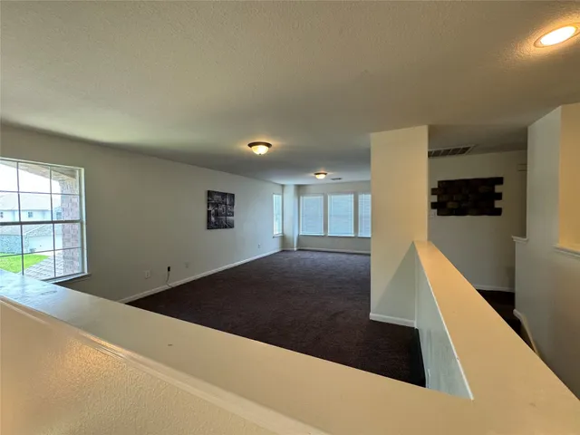 a view of a hallway to a room with windows