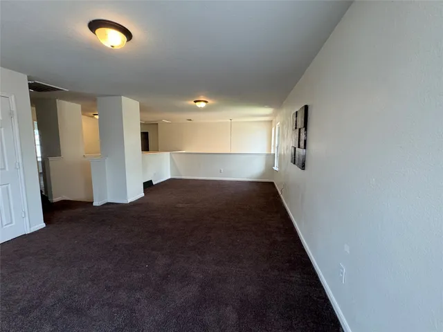 a view of empty room with window and wooden floor
