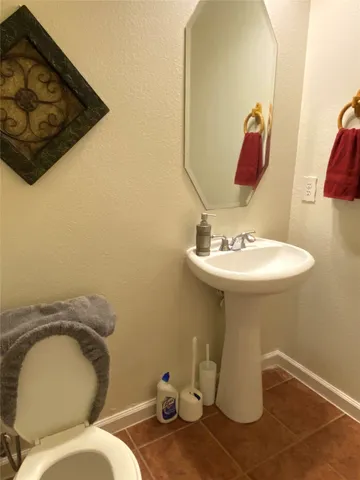 a bathroom with a sink mirror and toilet