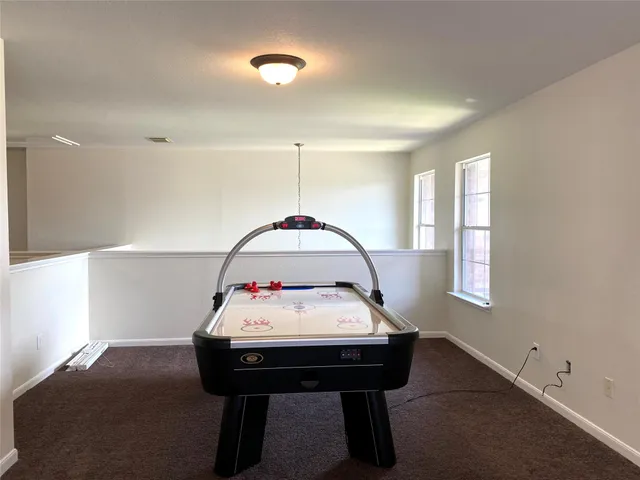 a room with a table chairs and window