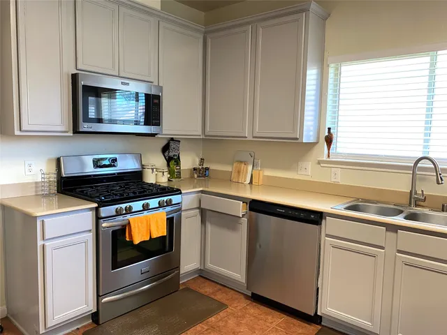 a kitchen with granite countertop white cabinets and white appliances