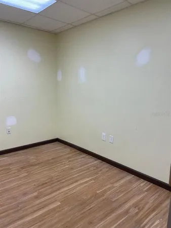 a view of an empty room with wooden floor