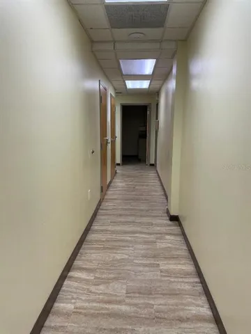 a view of a hallway with wooden floor