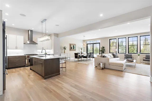 a large white kitchen with a large window and stainless steel appliances