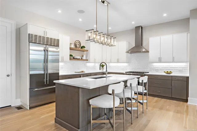 a kitchen with stainless steel appliances granite countertop a sink a stove a refrigerator and island