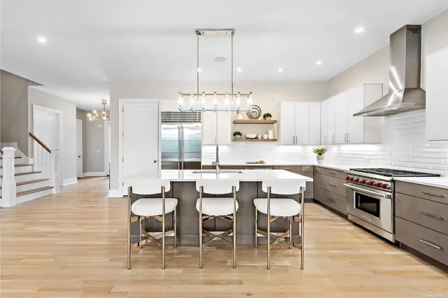 a kitchen with stainless steel appliances a table chairs sink and cabinets