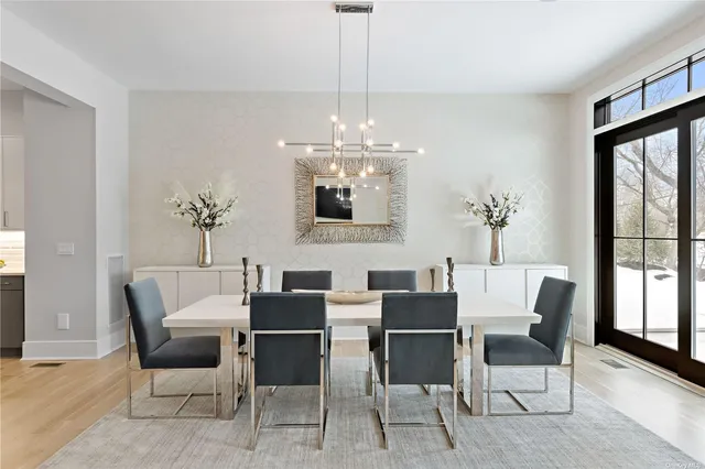 a dining room with furniture a chandelier and wooden floor