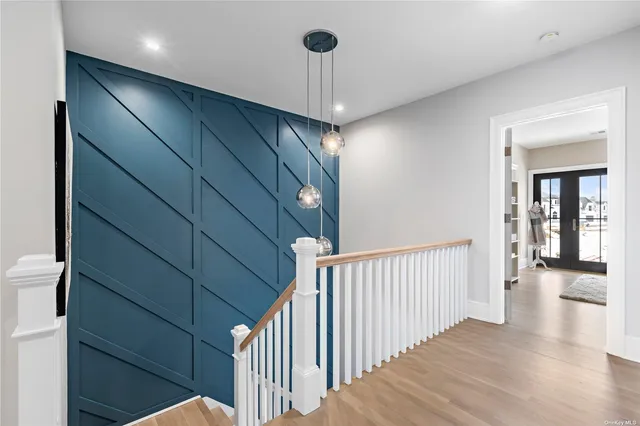 a view of a hallway to a room with wooden floor and stairs