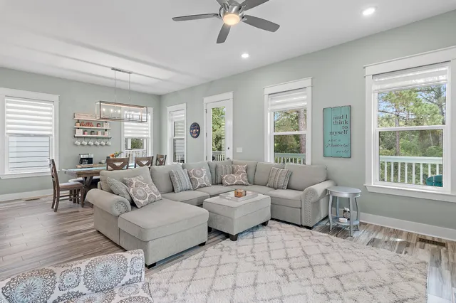 a living room with furniture and floor to ceiling windows