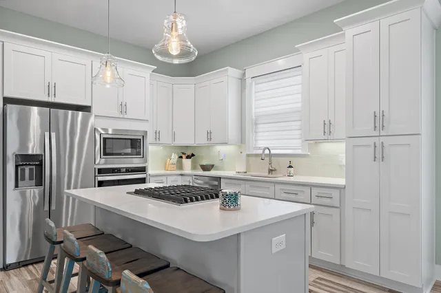 a kitchen with a sink stainless steel appliances and white cabinets
