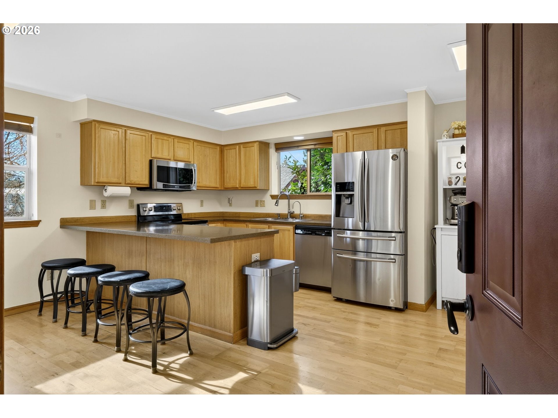 12132 Southeast Pardee Street Portland, OR 97266 - Photo 11 of 35 a kitchen with stainless steel appliances granite countertop a refrigerator a stove a sink a dining table and chairs