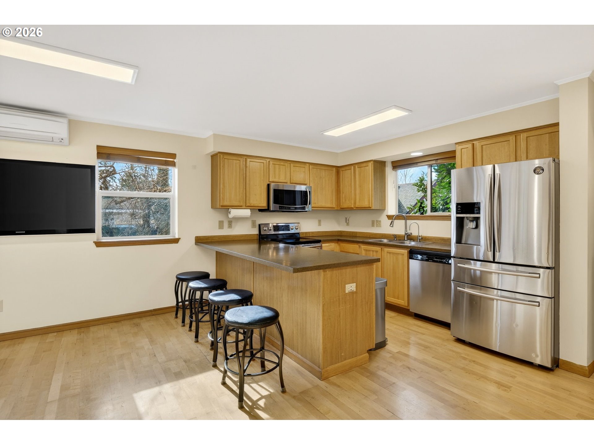 12132 Southeast Pardee Street Portland, OR 97266 - Photo 13 of 35 a kitchen with stainless steel appliances granite countertop a refrigerator a stove top oven a sink dishwasher and white cabinets with wooden floor