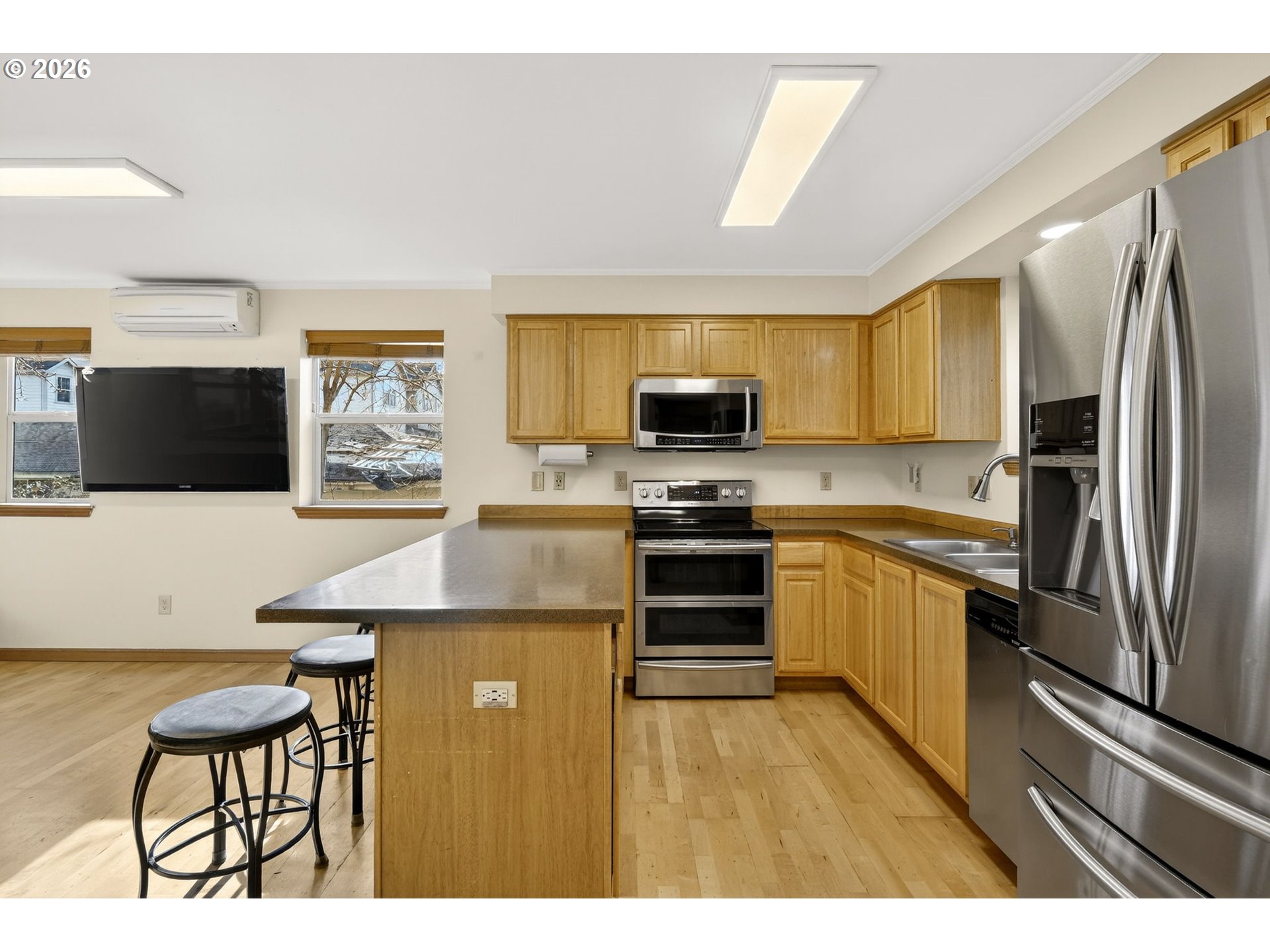 12132 Southeast Pardee Street Portland, OR 97266 - Photo 14 of 35 a kitchen with stainless steel appliances a microwave a stove a refrigerator a sink a dining table and chairs