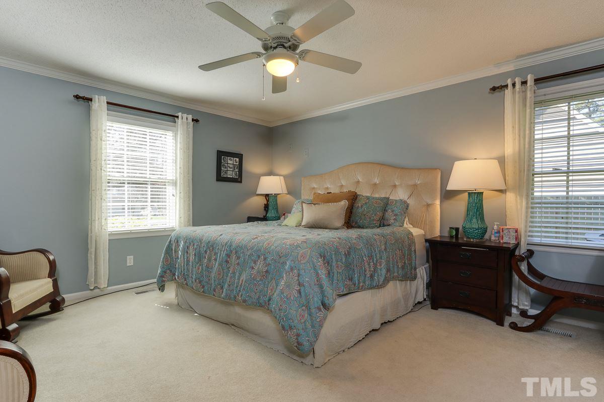 1705 Pony Run Road Raleigh, NC 27615 - Photo 12 of 22 a spacious bedroom with a bed a chandelier and a window