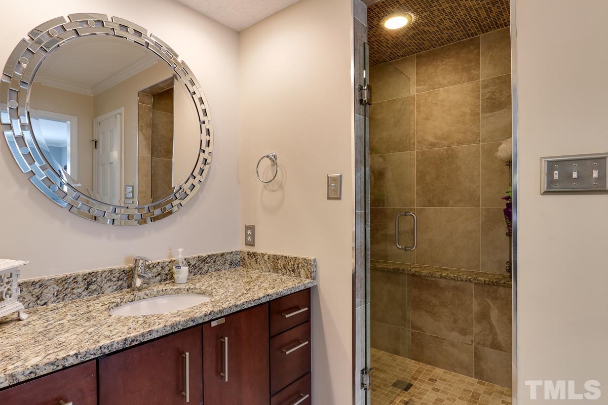 1705 Pony Run Road Raleigh, NC 27615 - Photo 14 of 22 a bathroom with a granite countertop sink a mirror and shower
