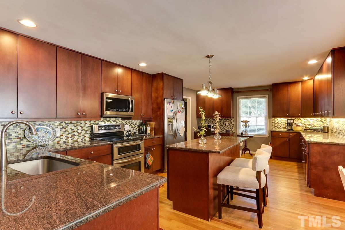 1705 Pony Run Road Raleigh, NC 27615 - Photo 3 of 22 a kitchen with stainless steel appliances granite countertop a sink dishwasher a refrigerator and a microwave with wooden floor