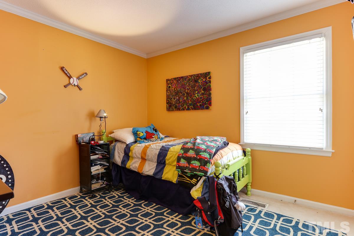 1705 Pony Run Road Raleigh, NC 27615 - Photo 21 of 22 a bedroom with a bed and a window